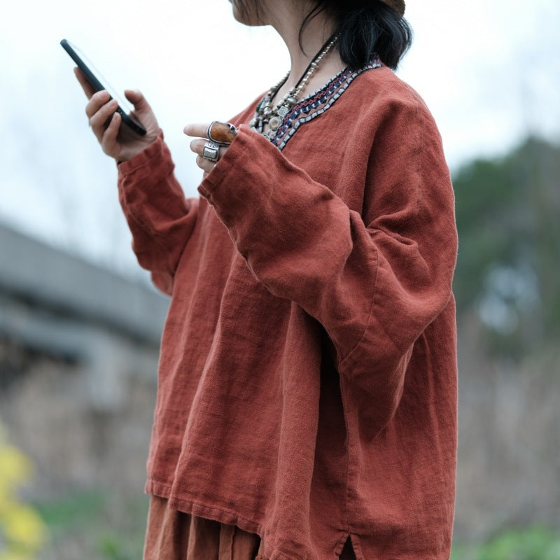 Close-up of hand-embroidered V-neckline detail on linen top