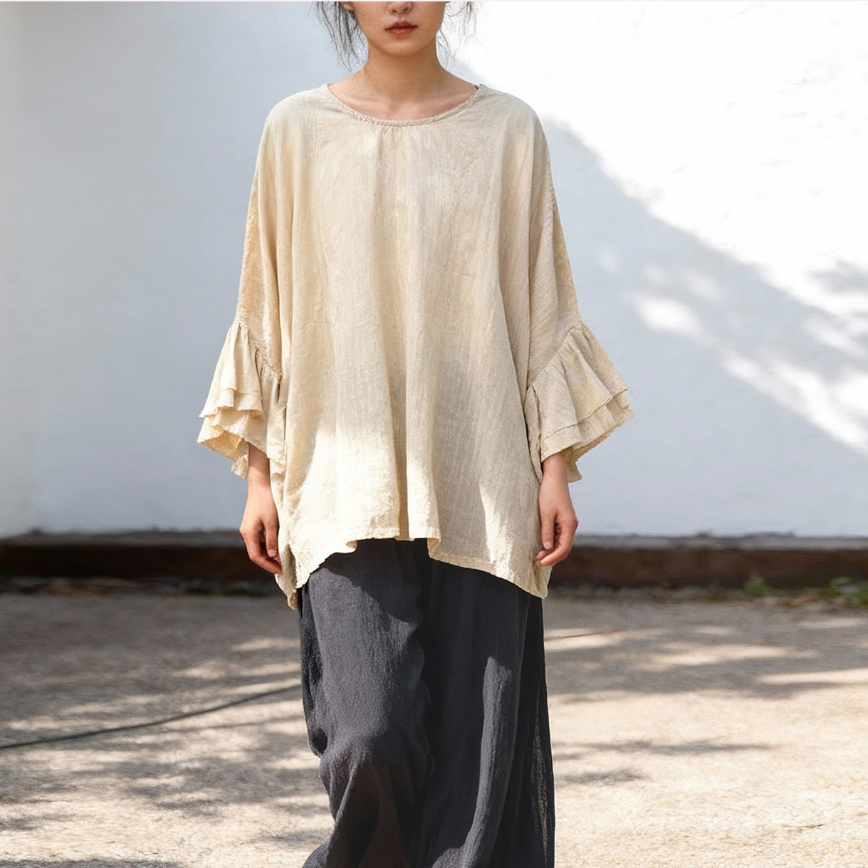 Front view of white cotton linen blouse with ruffle sleeves.